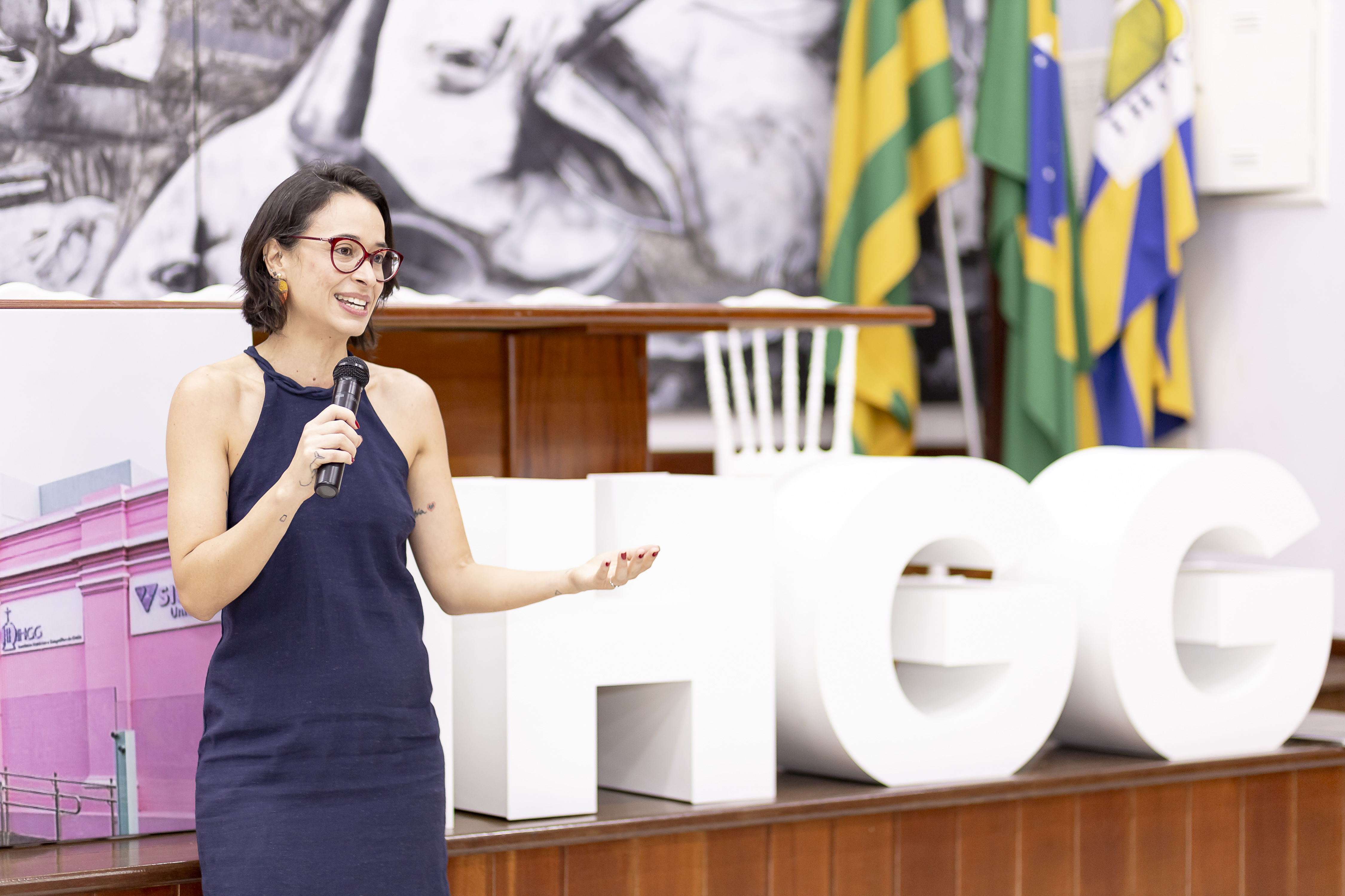 Aline Carrijo falando ao microfone no IHGG