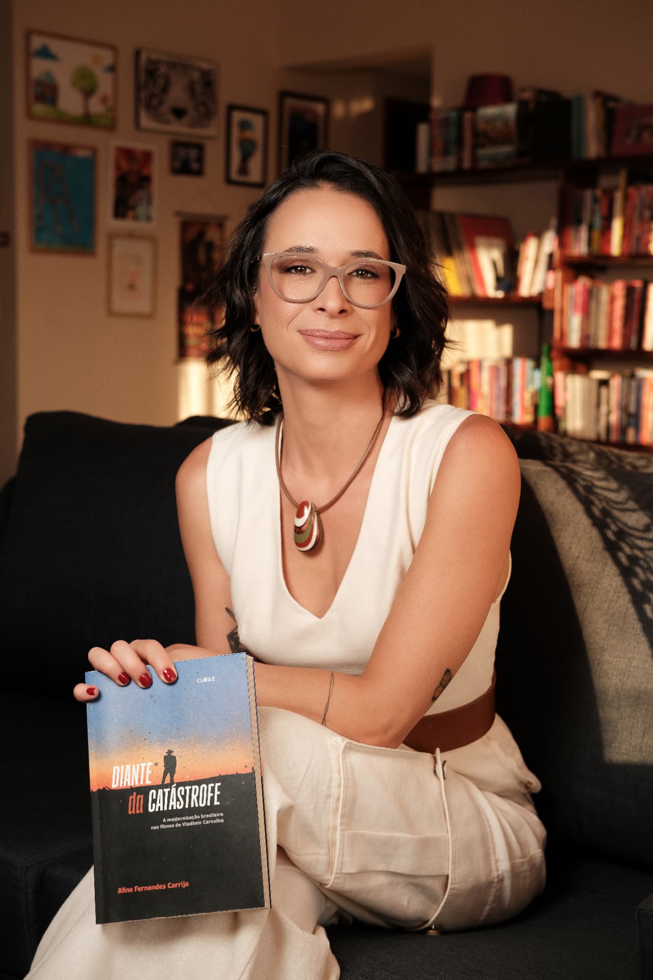 Aline Carrijo segurando o livro Diante da Catástrofe